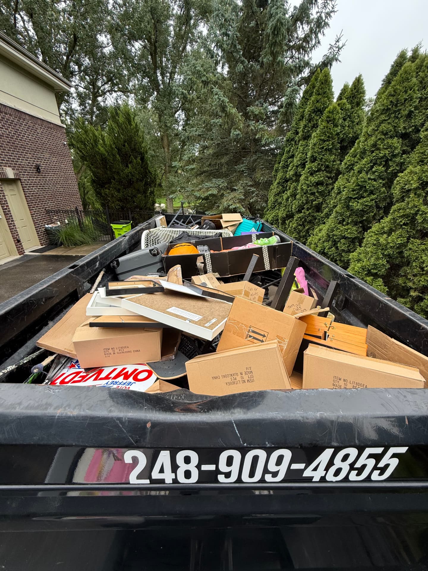 Dumpster Doll trailer full of boxes and household clutter at a Bloomfield Hills home