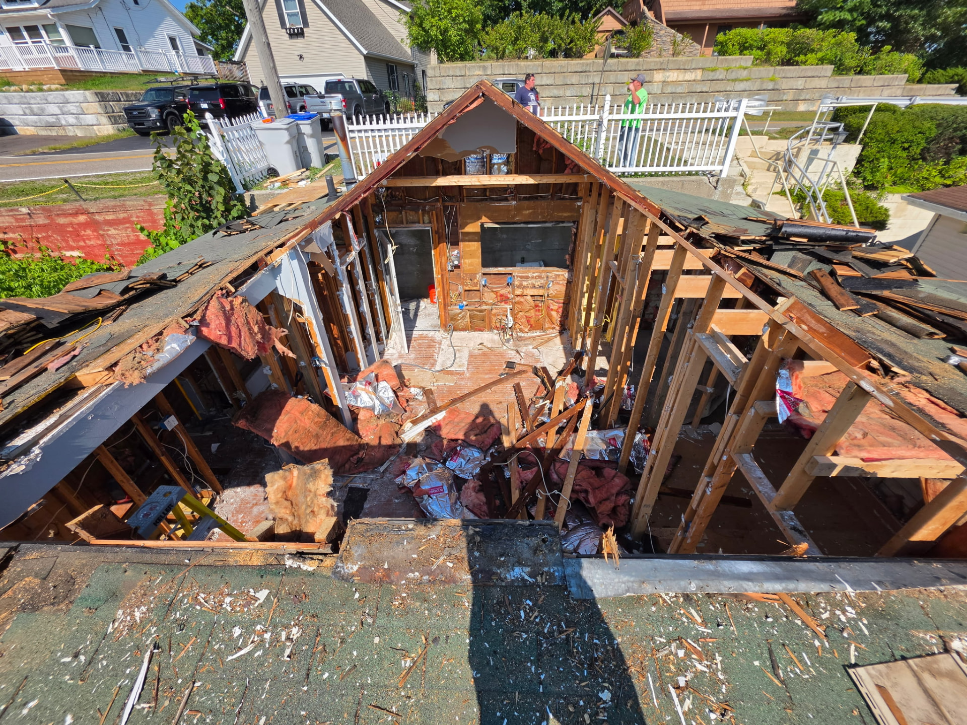 Aerial view of a roof and full house tear-down in Brighton, Michigan before a new home build